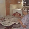 1972 - Clara Hinderer Baur baby sitting reading folding newspapers.jpg